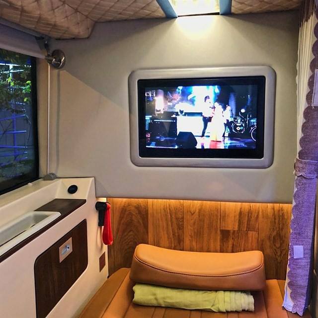 A room with a chair and a television on the wall