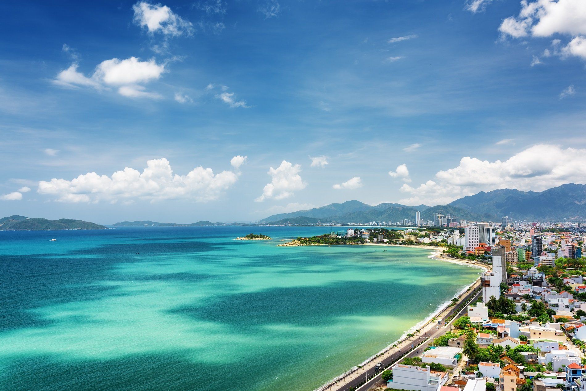 An aerial view of a city surrounded by water and mountains.