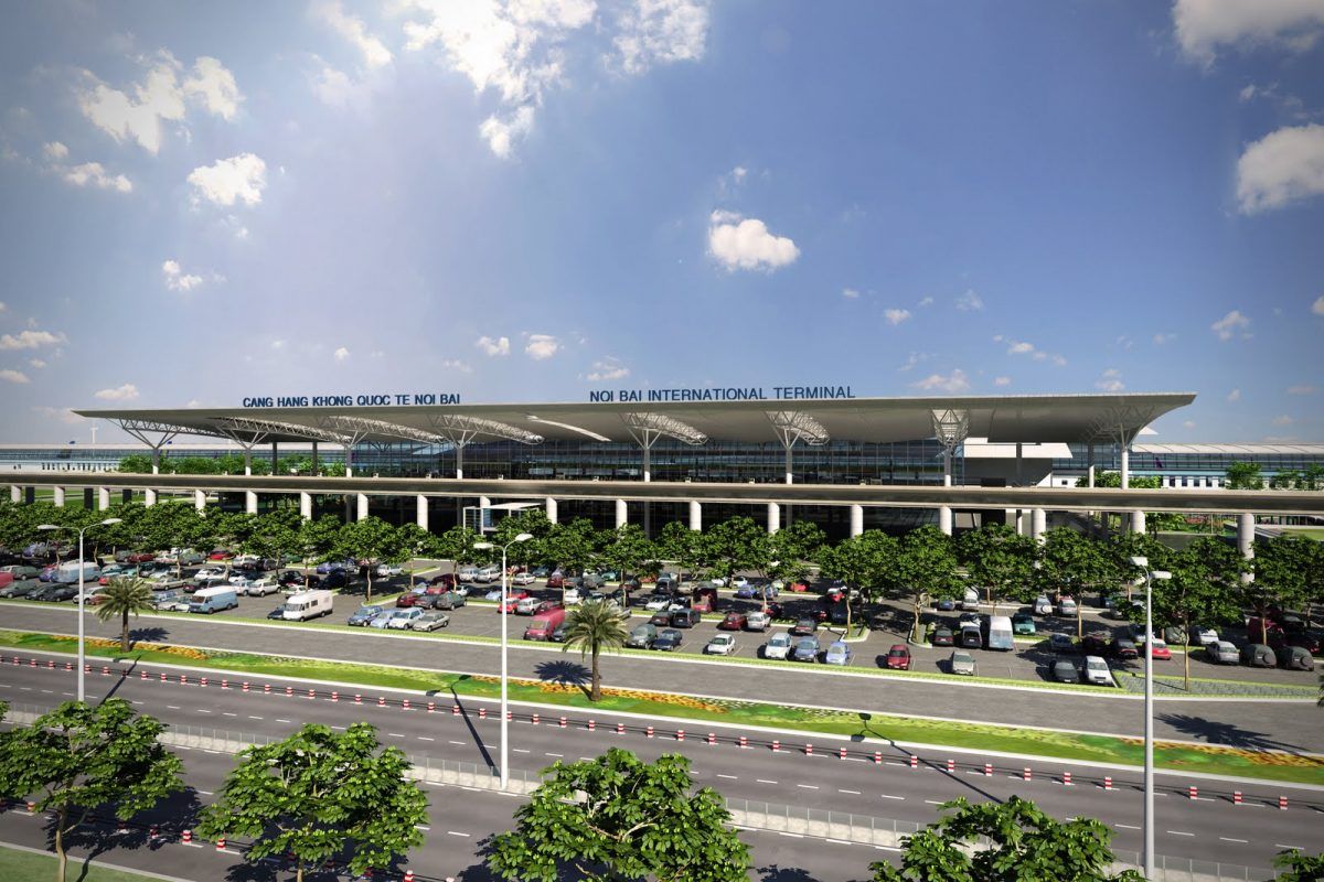 An aerial view of an airport with a lot of cars parked in front of it.