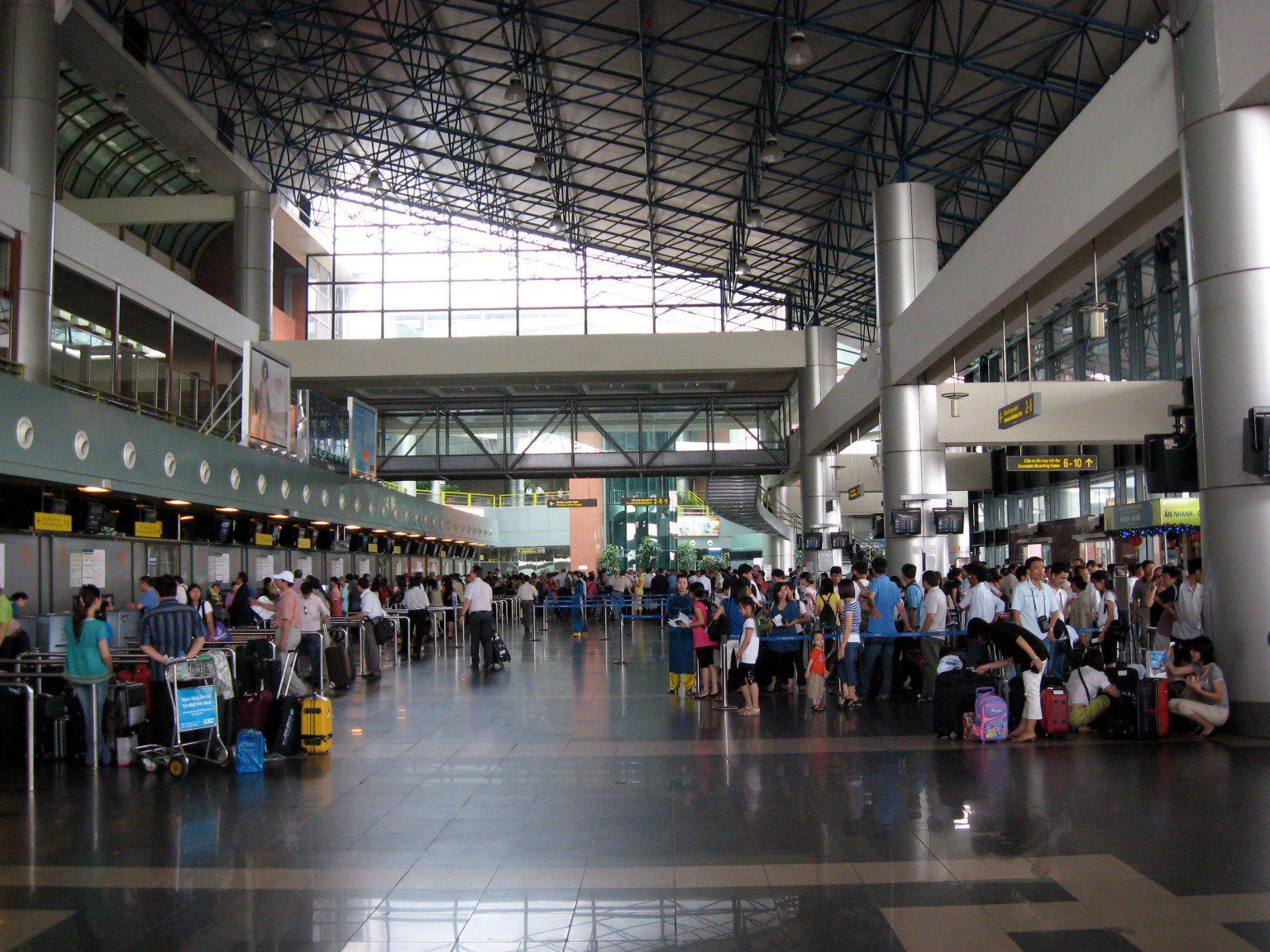 A crowded airport with a sign that says exit