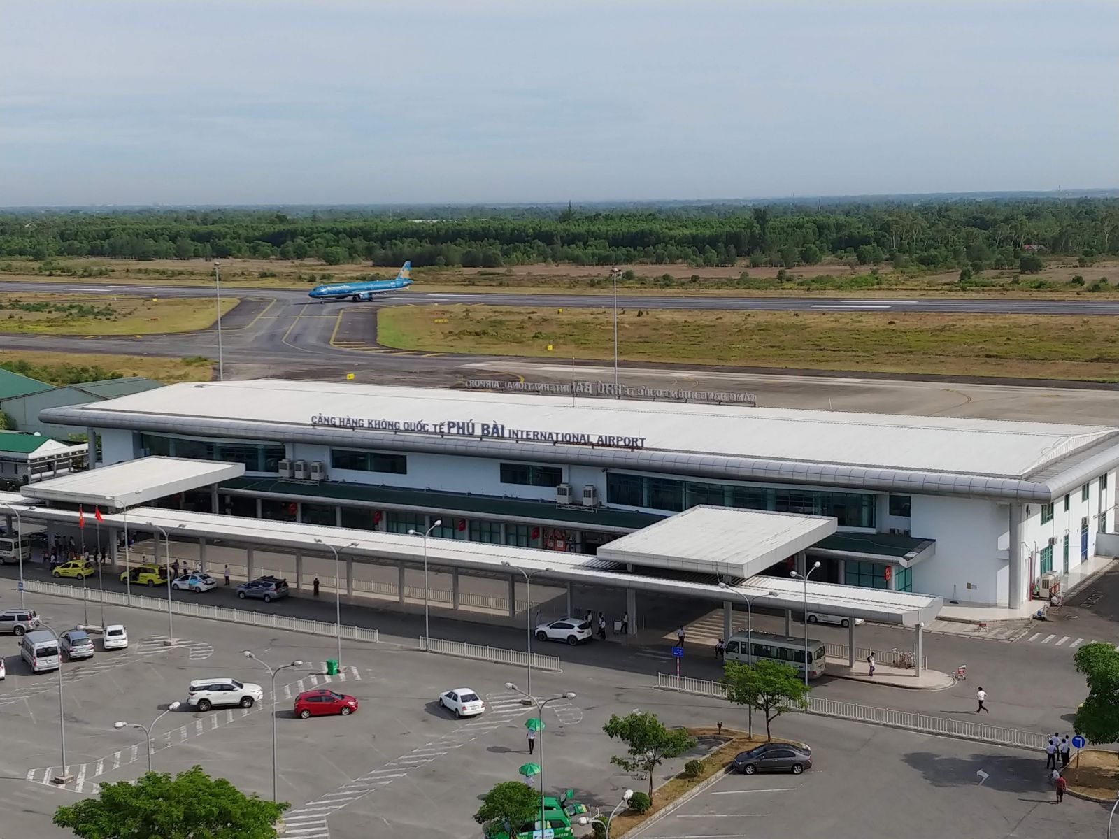 An aerial view of an airport with a plane taking off from the runway.