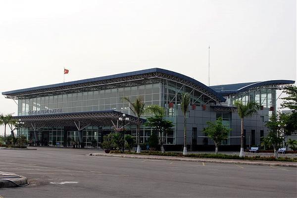 A large building with a lot of windows and palm trees in front of it.