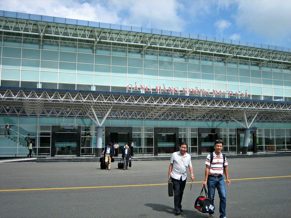 Two men are walking in front of a large glass building