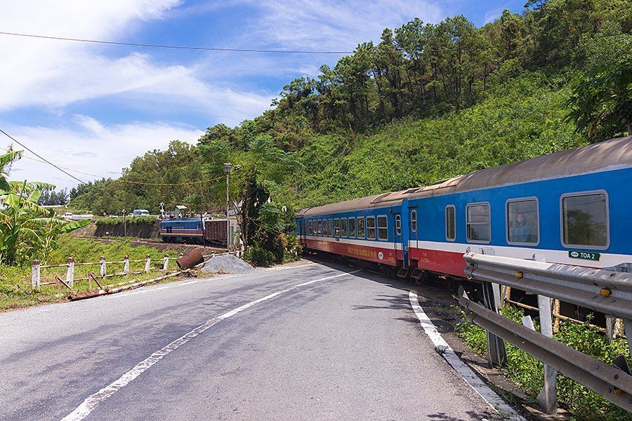 A blue and red train is going down a road.