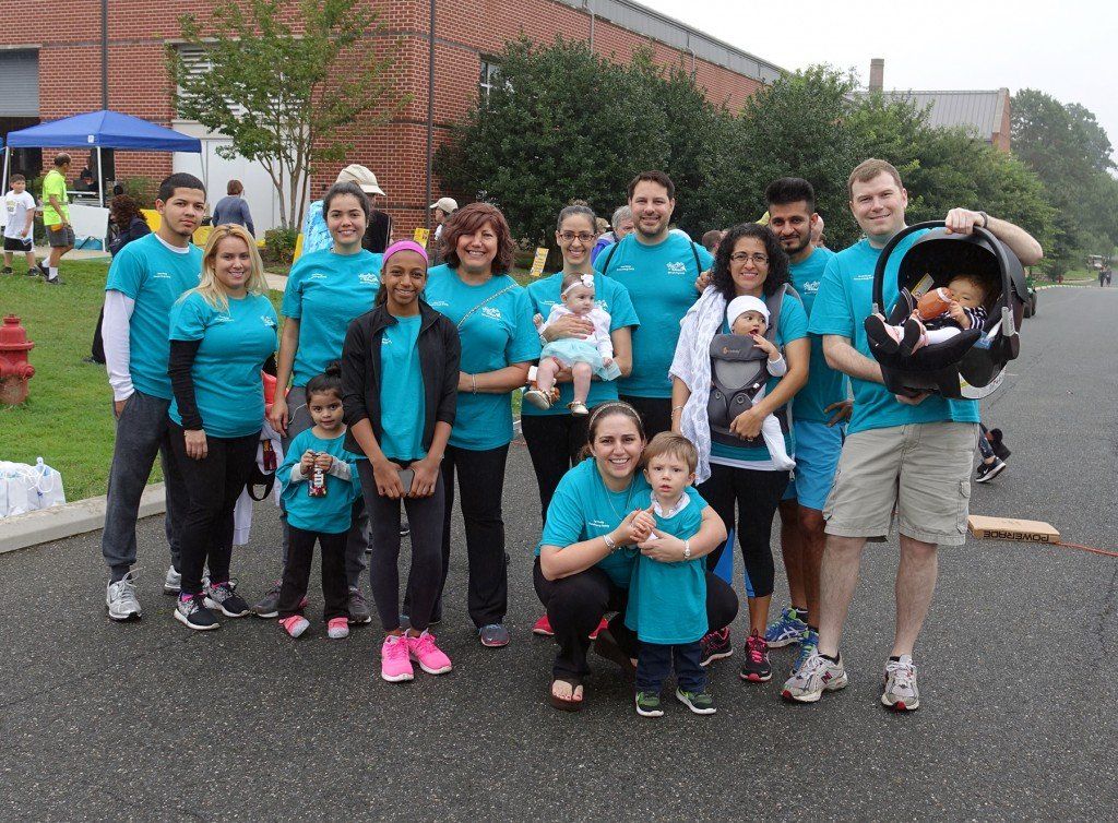 A group of people wearing blue shirts are posing for a picture.