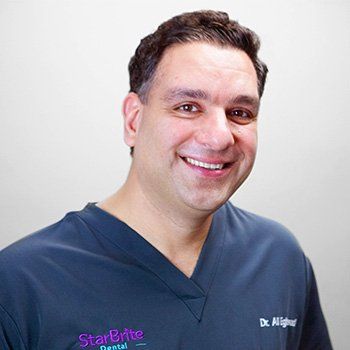 Dr. Ali in a blue scrub is smiling for the camera.