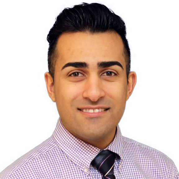 Dr. Karimi in a plaid shirt and tie is smiling for the camera