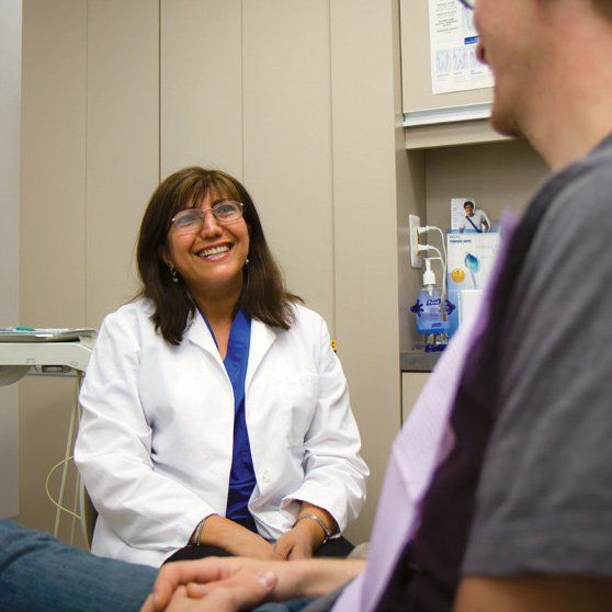 A woman in a lab coat is talking to a man