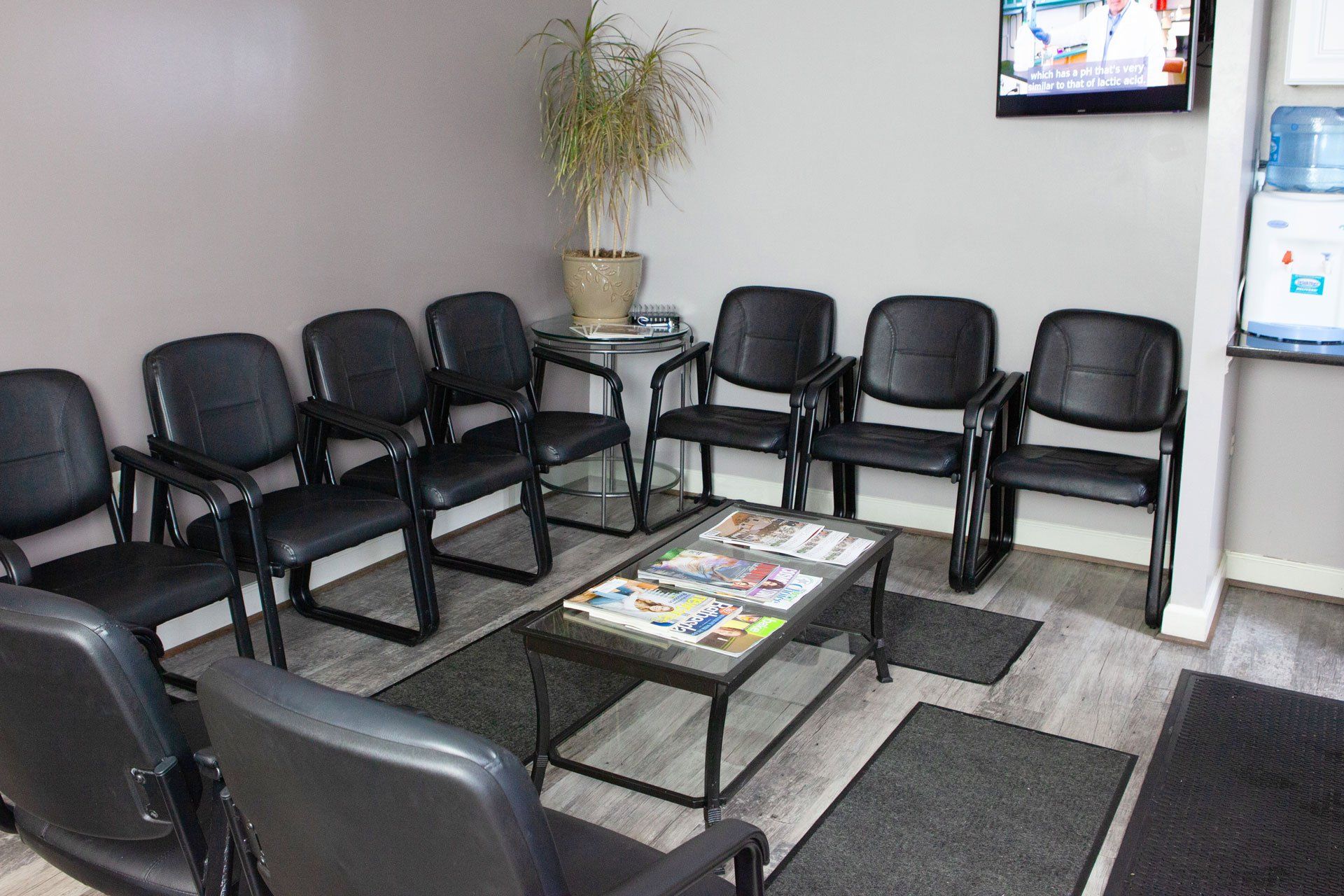 A waiting room with black chairs and a coffee table.