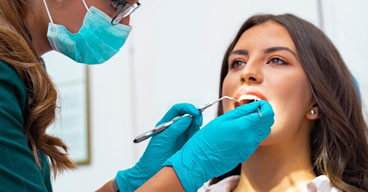 female dentist examining female patient for tooth erosion