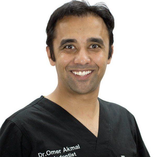 Dr. Akmal wearing a black scrub top with the name dr. omer akmal on it