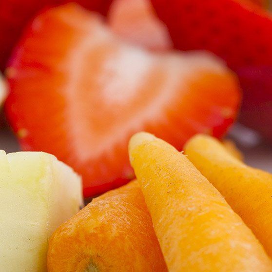 A close up of carrots and strawberries on a plate.