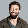 A man with a beard is smiling for the camera.