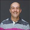 A man in a striped shirt is smiling for the camera.