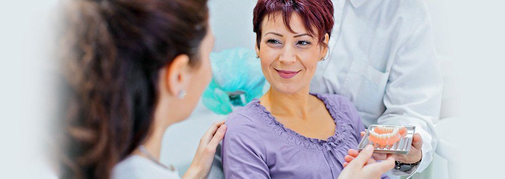 Woman in her mid 40's asking questions regards implant dentures