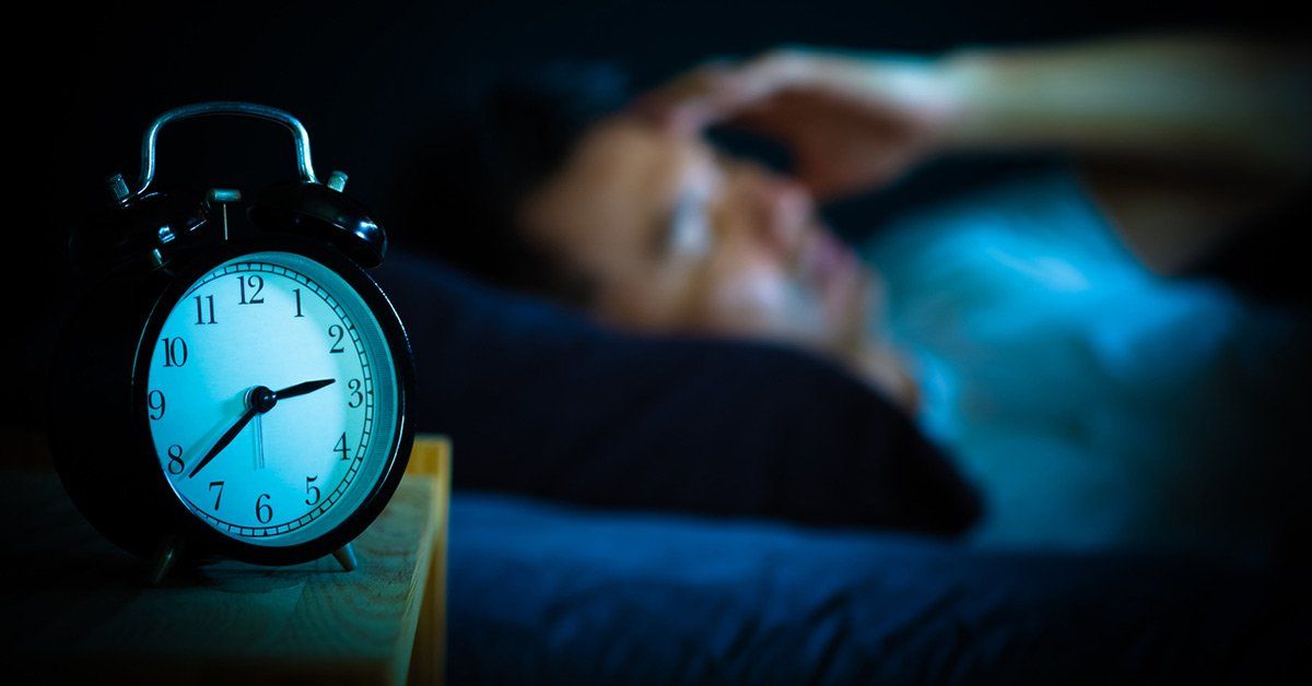 man awake in bed due to sleep apnea