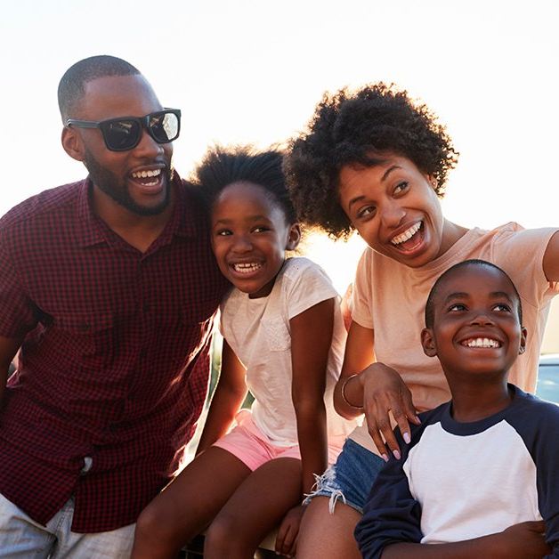A family is posing for a picture and smiling for the camera