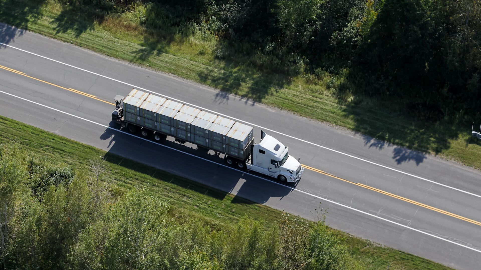 Une vue aérienne d'un semi-remorque roulant sur une autoroute.