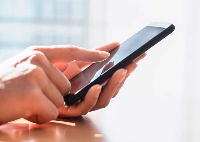 hand of person tapping a smartphone hand of person tapping a smartphone