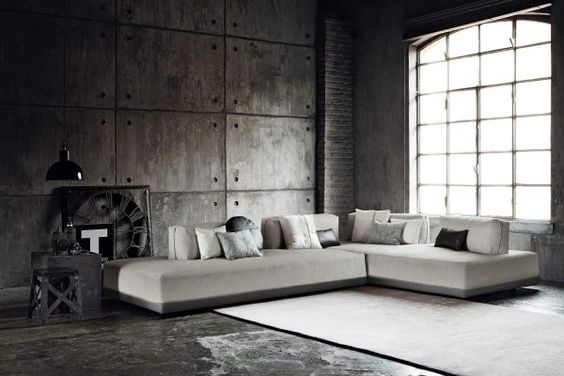 Een woonkamer met een grote design hoekbank van Ditre Italia en een groot raam