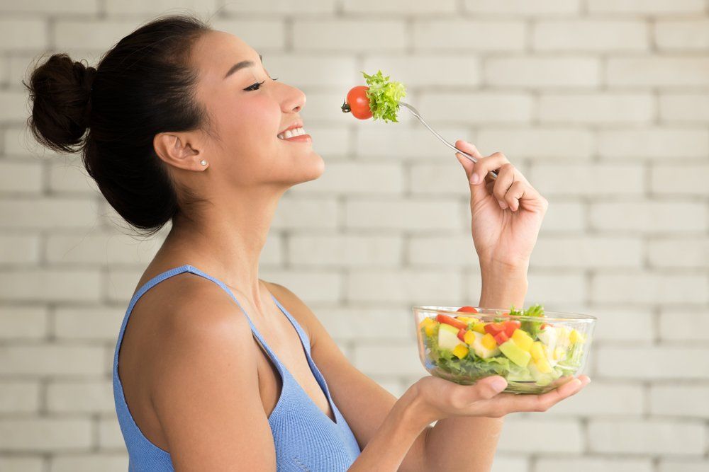 Woman Eating Vegetable Salad — Chicago, IL — Southtown Health Foods
