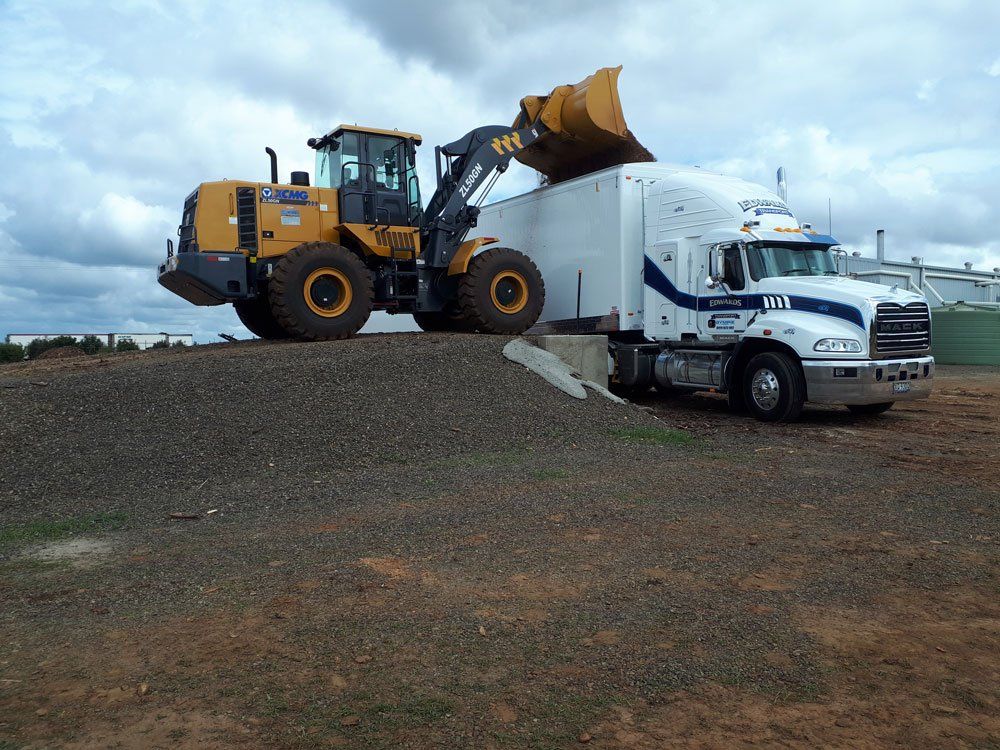 Bulldozer And Truck For Transporting Commercial Goods — Edwards Transport, Cartage & Haulage in Gympie, QLD Bulldozer And Truck For Transporting Commercial Goods — Edwards Transport, Cartage & Haulage in Gympie, QLD