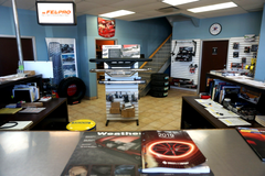 À l'intérieur d'un magasin de pièces détachées automobiles : présentoirs, comptoirs et quelques clients.