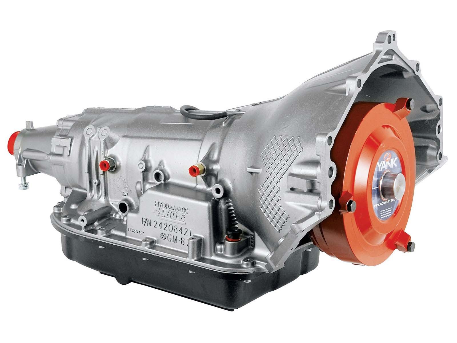 Transmission automatique argentée et noire avec un convertisseur de couple orange, posé sur une surface.