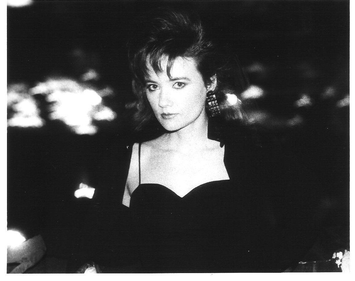 A black and white photo of a woman in a black dress