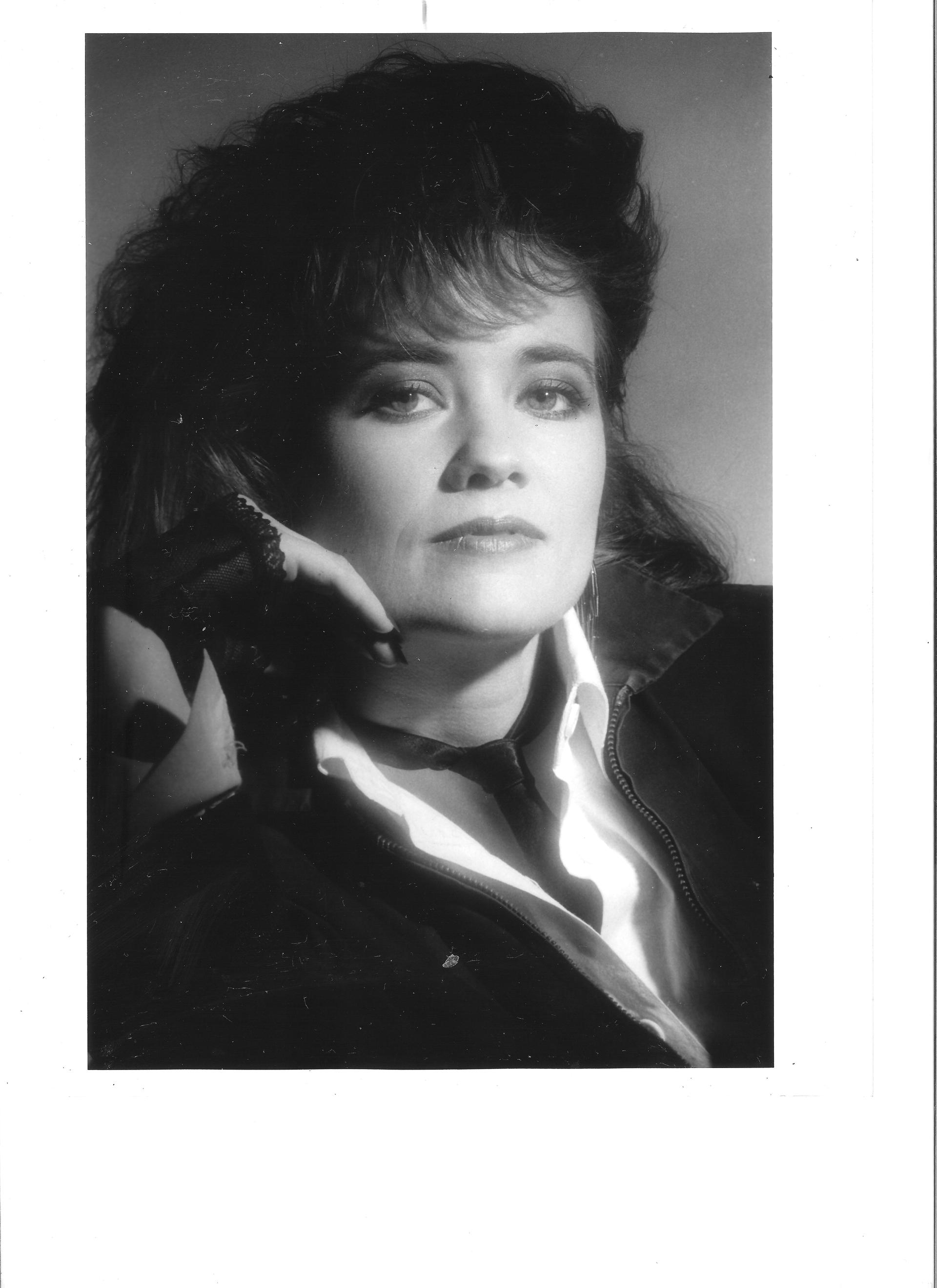 A black and white photo of a woman talking on a cell phone.