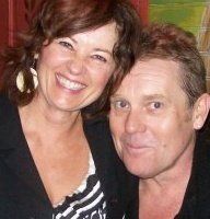 A man and a woman are posing for a picture together and smiling.