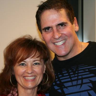 A man and a woman are posing for a picture and smiling for the camera.
