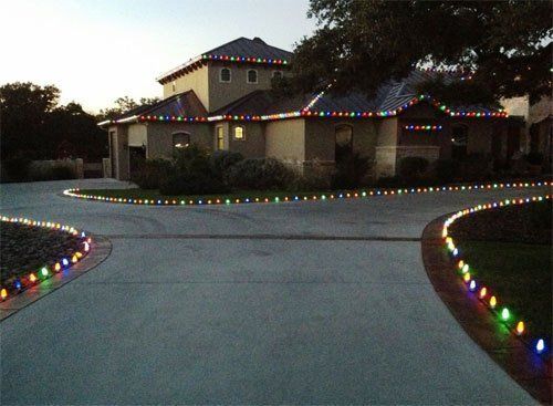 Holiday lighting along driveway and around a two story house