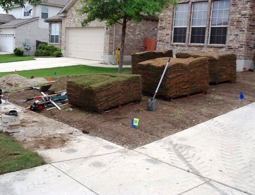 Stacks of grass next to driveway