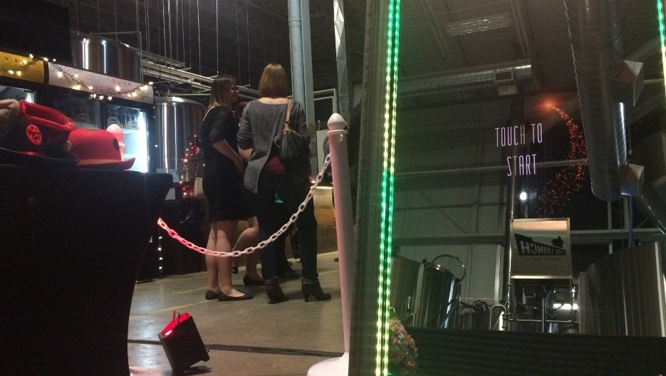 People standing near bar and stage with lights.