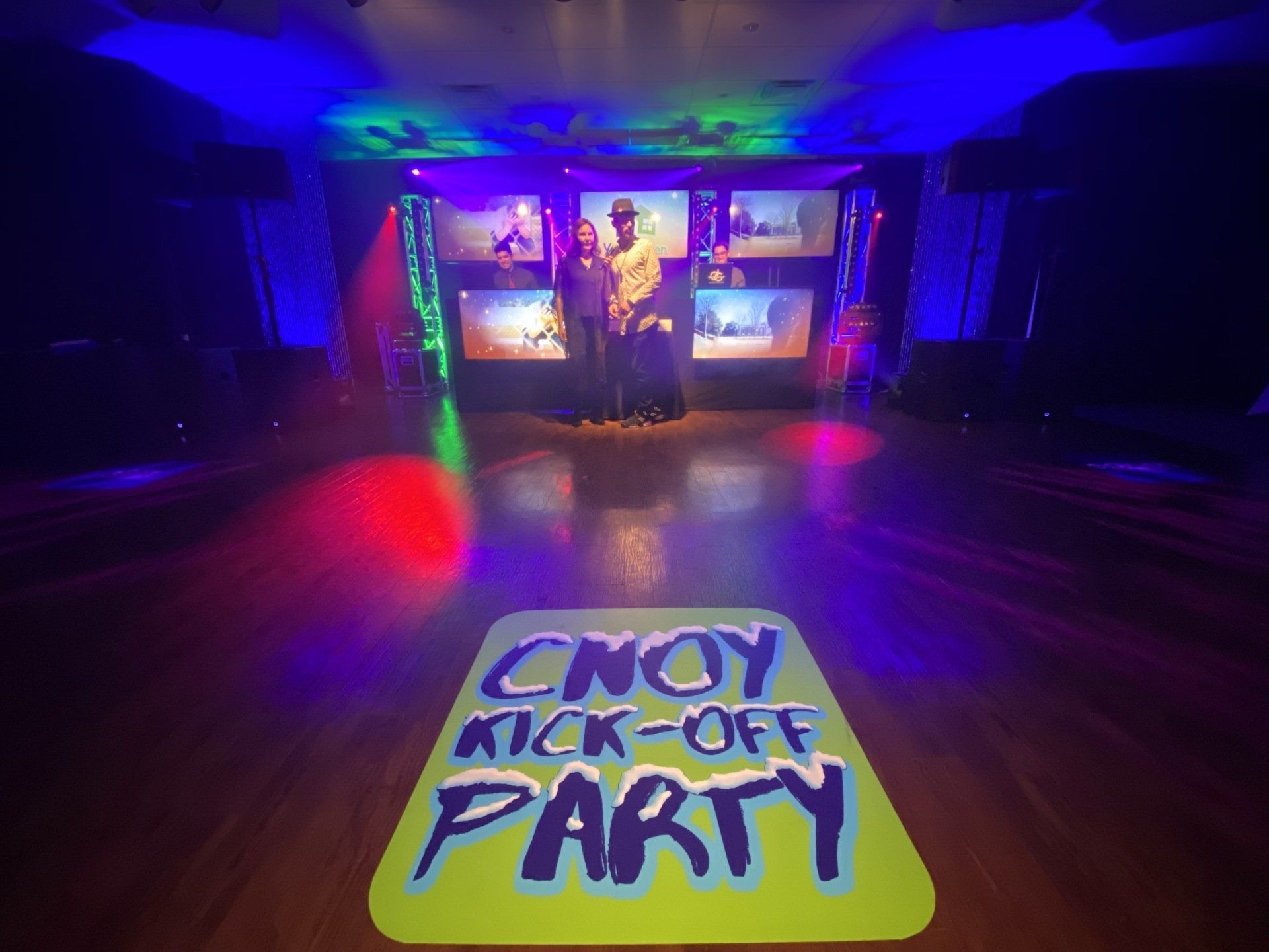 A couple poses on a stage with a 