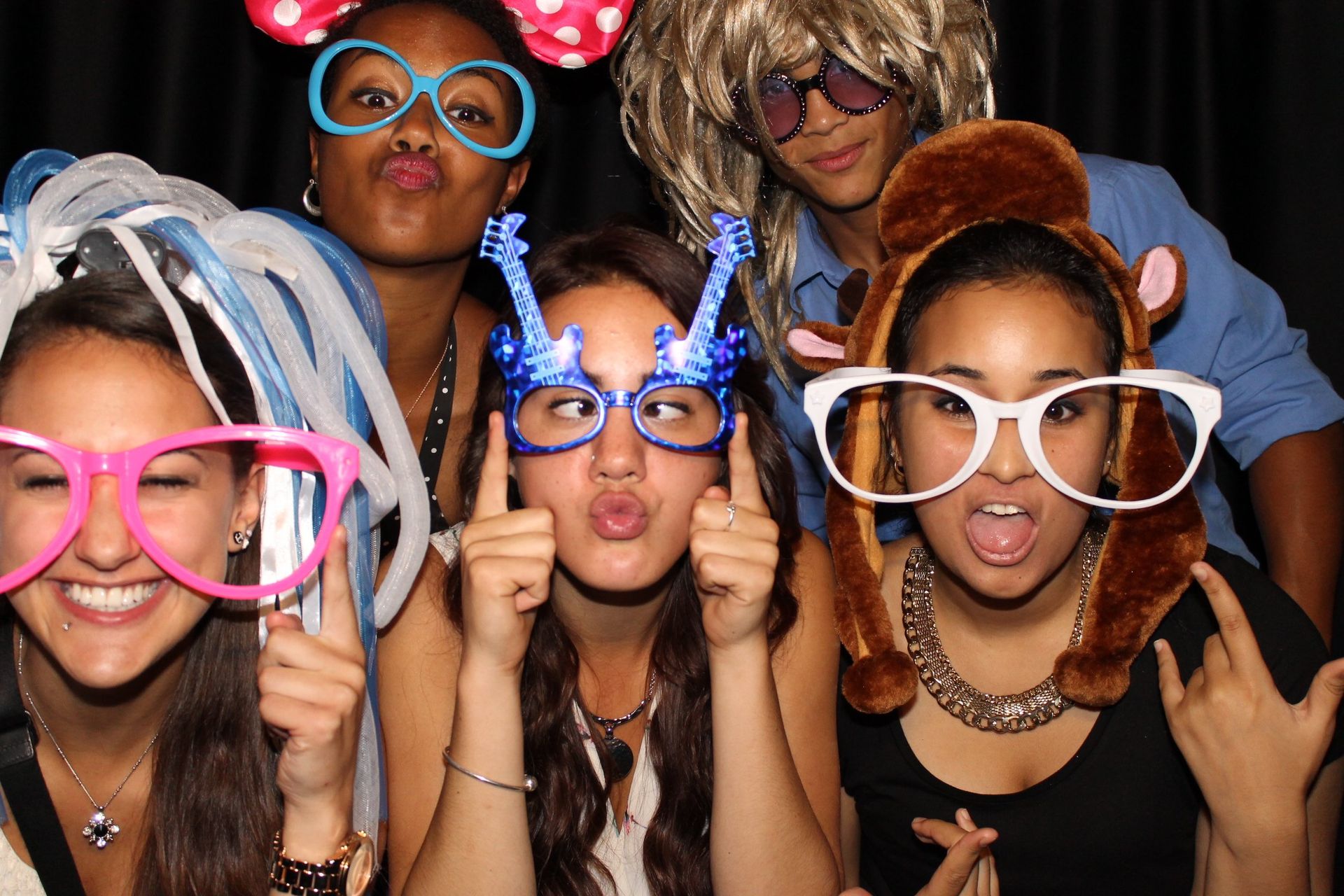 Group of people posing with fun props, making silly faces.