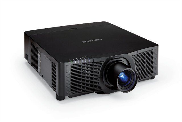 Black projector with a lens projecting blue light, on a white surface.