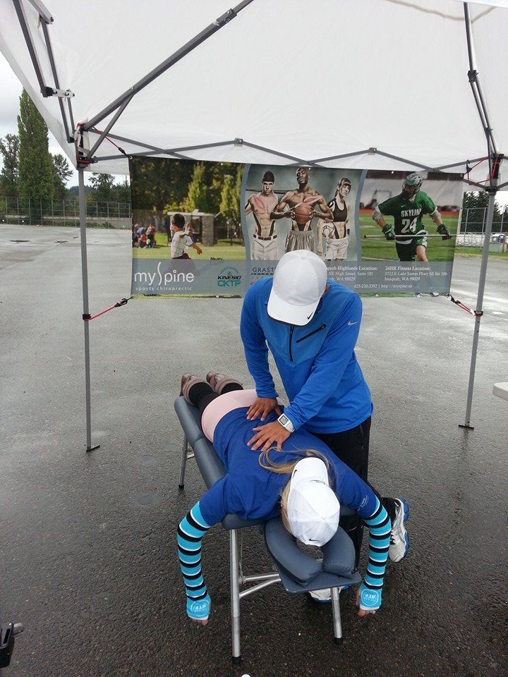 A man is giving a woman a massage under a tent