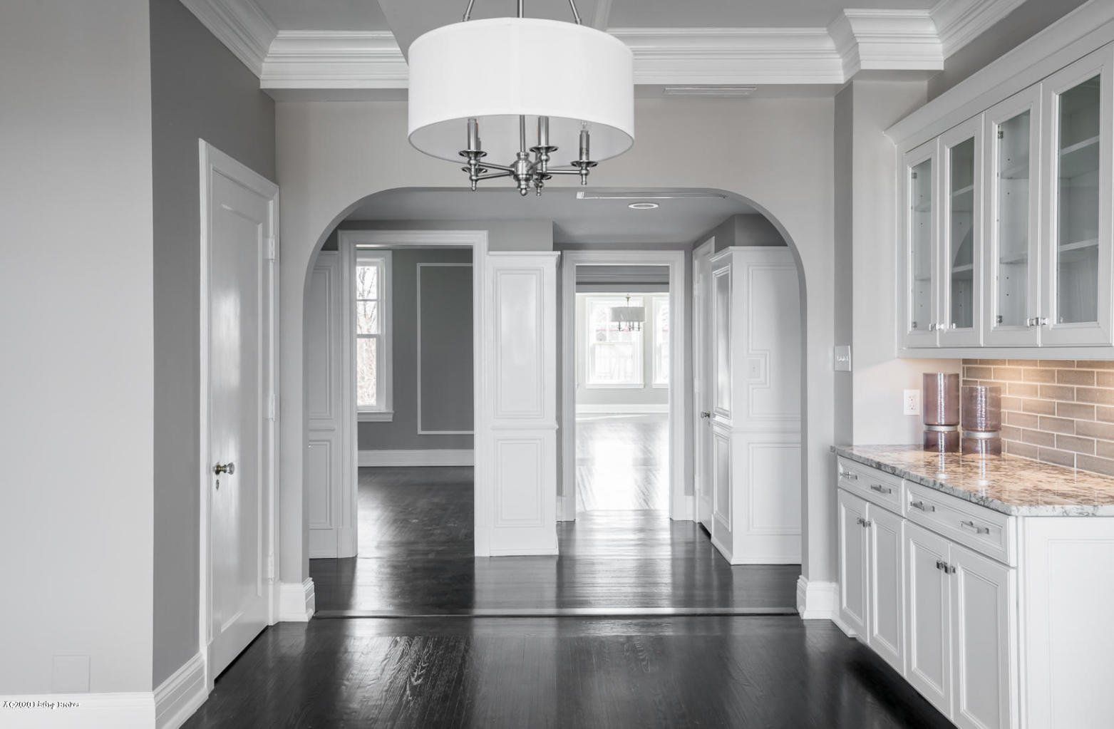 Interior hallway with gray walls, white trim, and dark wood floors.