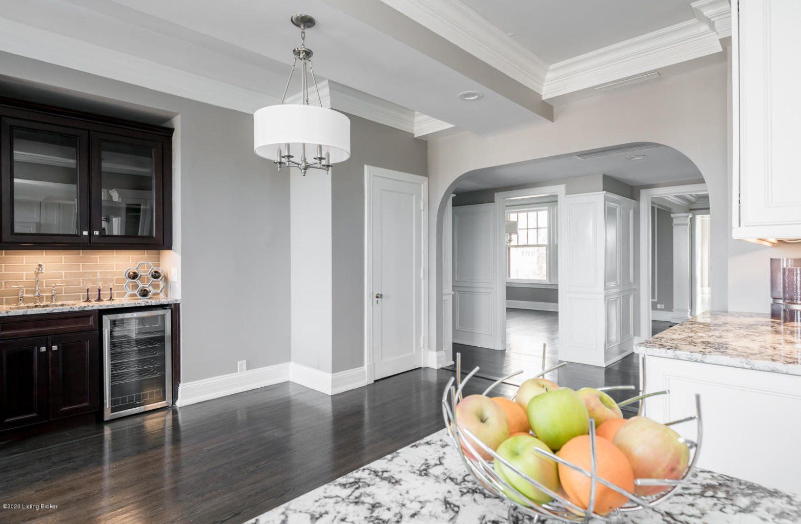 Kitchen with gray walls, dark wood floor, and a fruit bowl on the counter.
