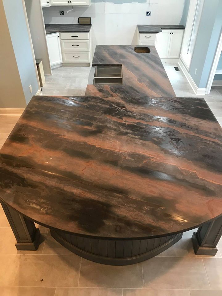 Dark wooden dining table with a built-in fire pit in a modern kitchen-dining area