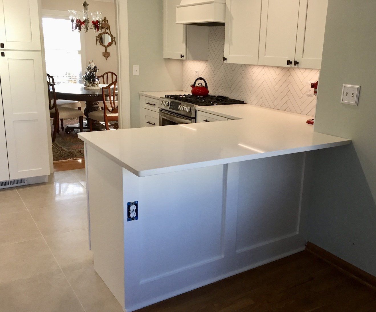 White kitchen with quartz countertops and a breakfast bar.