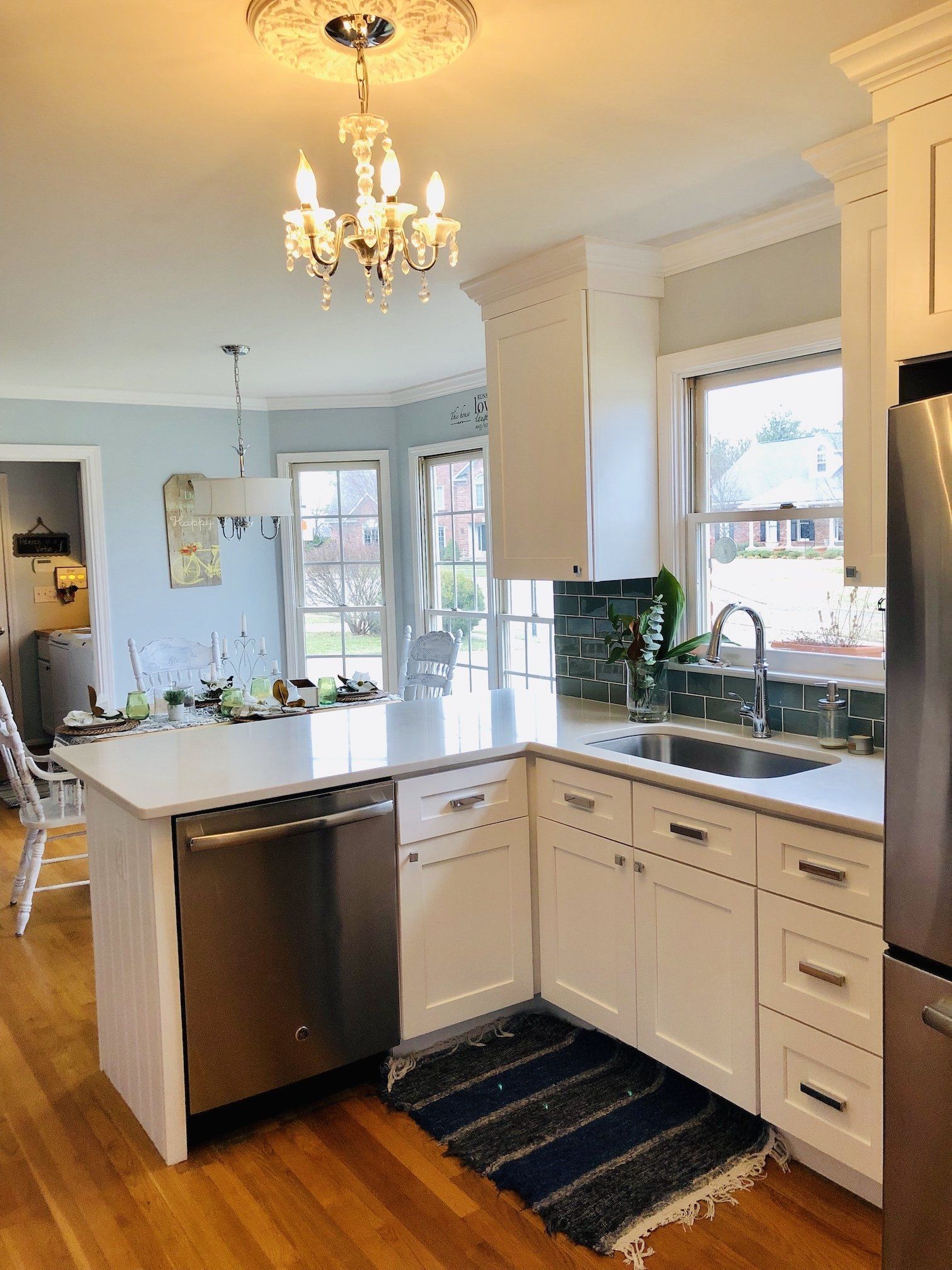 Kitchen with white cabinets, stainless steel appliances, and a chandelier.