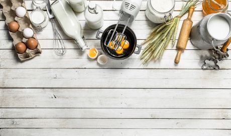 un tavolo in legno bianco con sopra attrezzi da cucina