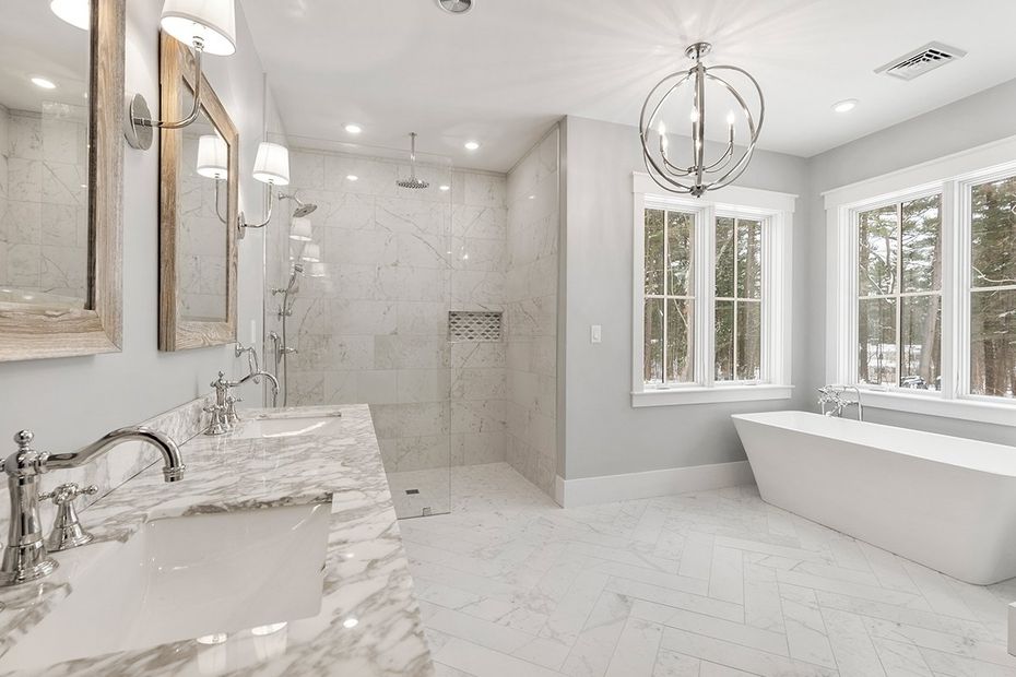 Bright white luxury bathroom with marble vanity, walk-in shower, soaking tub, and large windows