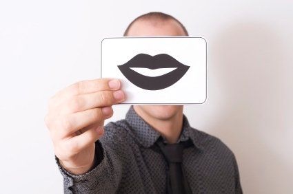 Person holding a drawing of a pair of lips in front of their face. Person holding a drawing of a pair of lips in front of their face.