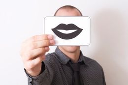 Person holding a drawing of a pair of lips in front of their face. Person holding a drawing of a pair of lips in front of their face.