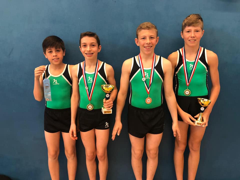 Gymnast wearing medals, smiling and celebrating after a competition