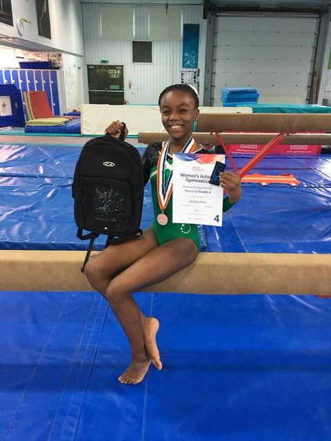 gymnast with a medal after qualifying to compete at national finals